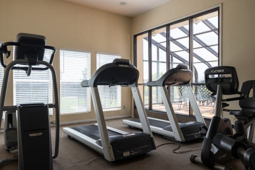 A fitness center at Hawthorne Apartment Homes with a variety of exercise equipment for residents.